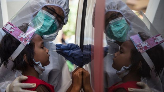 Seorang anak menjalani tes swab virus corona COVID-19. Foto : AFP.